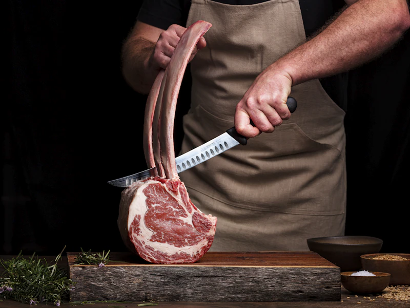 骨付きの牛肉を包丁で切り分ける